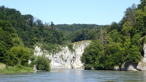 Scenic view of waterfall in forest against clear sky