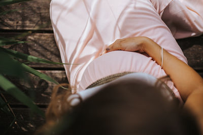 High angle view of woman hand on bed