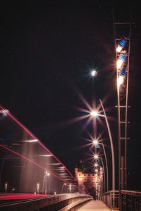 Low angle view of light trails in city against sky at night