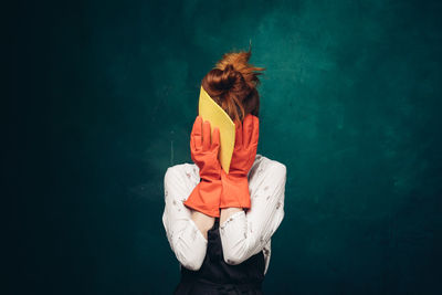 Rear view of woman standing against gray background