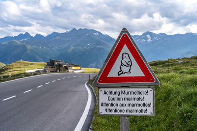 Information sign by road against sky