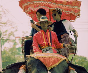 Rear view of people sitting on red wall