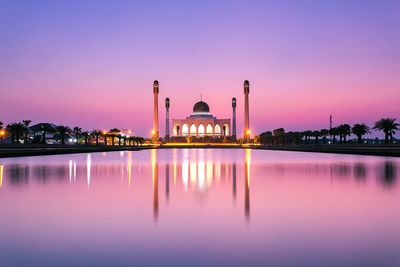 Songkhla central mosque by lake against sky during sunset 