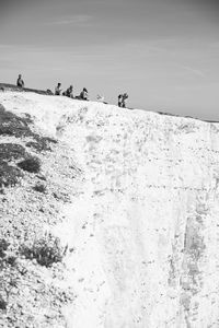 People on snowcapped mountain against sky