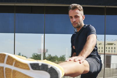 Sportsman stretching muscles after exercise.