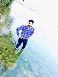 High angle view of young man standing in water
