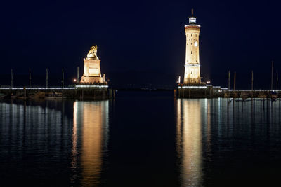 Illuminated building by lighthouse at night at lindau harbur