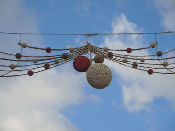 Low angle view of christmas street decoration hanging against sky