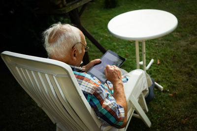 Rear view of man sitting on table