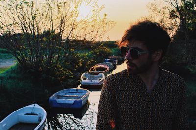 Side view of young man in sunglasses at sunset