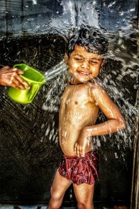 Full length of shirtless boy in water