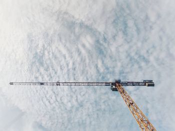 Low angle view of crane against sky