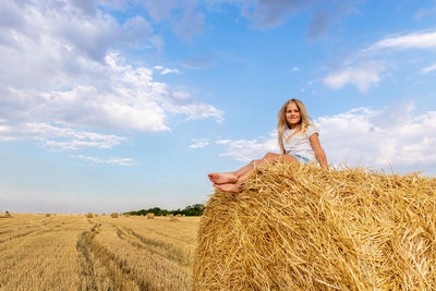 Rear view of woman standing on field against sky