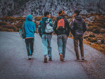 Rear view of people walking on road