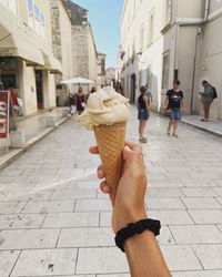 Woman holding ice cream in city