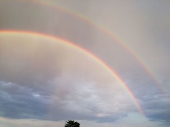 Low angle view of rainbow against sky during sunset