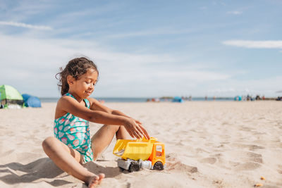 Side view of woman sitting at beach