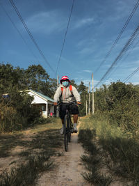 Man riding bicycle on land against sky