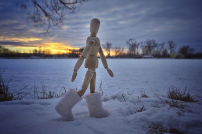 Full length of frozen lake on field against sky during winter