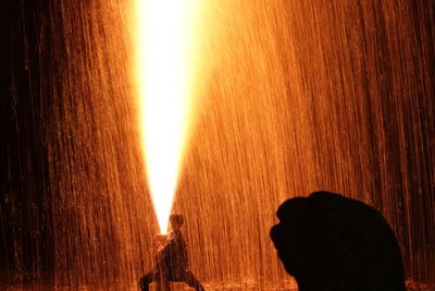 Close-up portrait of silhouette man standing against orange sky