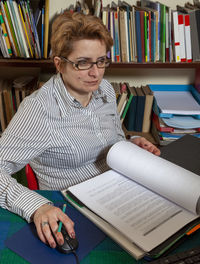 Image of a busy woman teleworking at her desk at the home. 