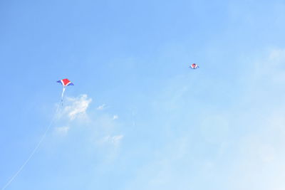 Low angle view of kite flying against blue sky