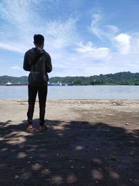 Rear view of man standing on beach