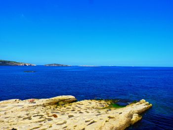 Scenic view of sea against clear blue sky