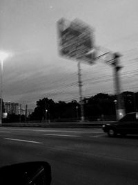 Blurred motion of illuminated street against sky