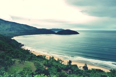 Scenic view of sea and mountains against sky