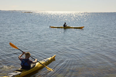 Men kayaking on sunny day