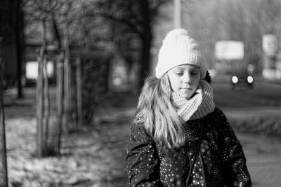 Girl wearing warm clothing while walking on footpath