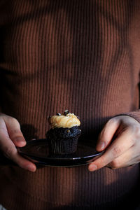 Midsection of woman holding cake