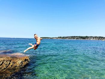 Man in sea against clear sky