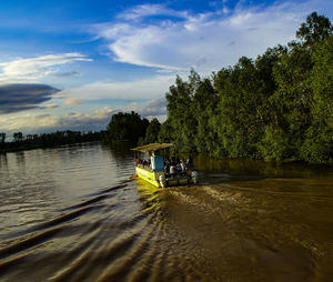 Boat sailing on river against sky