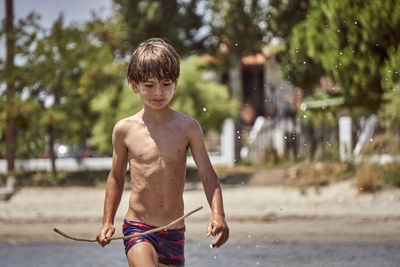 Full length of shirtless boy in water