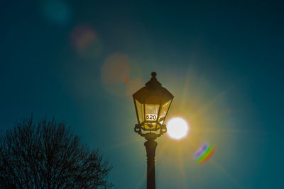 Low angle view of illuminated street light against blue sky