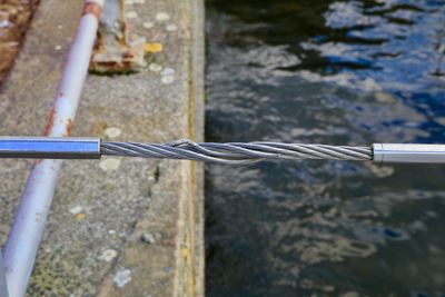 Close-up of metal rope tied to metal railing