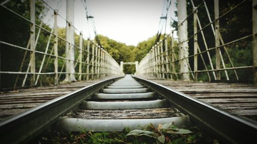 Railroad tracks amidst trees against clear sky