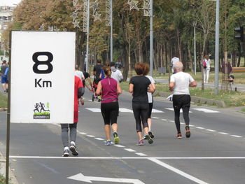 Rear view of people walking on road