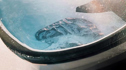 View of snowcapped mountain seen through airplane window