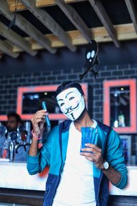 Portrait of man wearing mask while standing in store