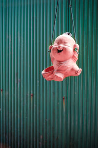 Toy hanging against corrugated iron