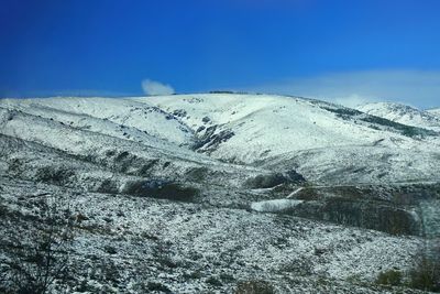 Scenic view of snowcapped mountain against blue sky