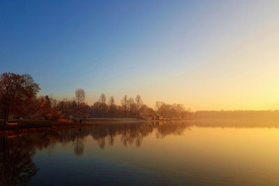 Scenic view of lake against sky at sunset