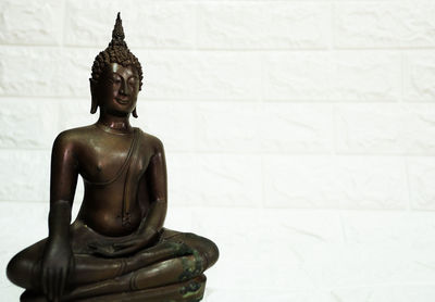 Statue of buddha against wall