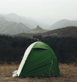 Tent on field by mountain against sky