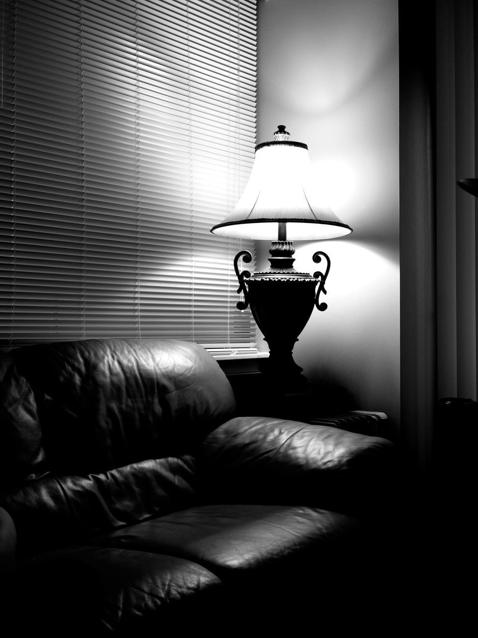 CLOSE-UP OF ILLUMINATED LAMP ON BED