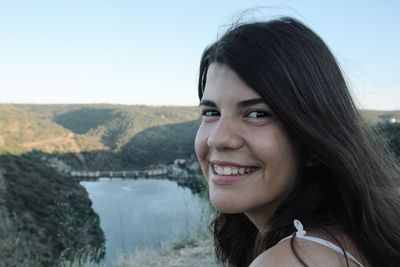 Portrait of happy young woman against mountains and clear sky at miranda do douro