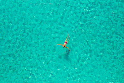 Aerial view of a girl floating in the turquoise sea of the sakarun beach, adriatic sea, croatia